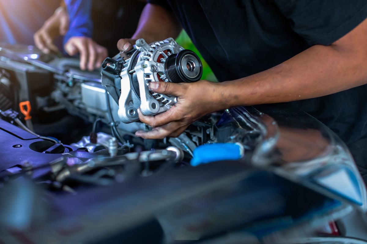 Mechanic working on car engine in auto shop